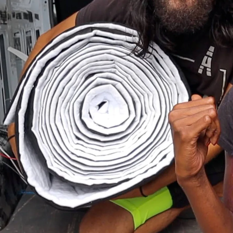 A roll of white insulation held up inside the Sprinter van
